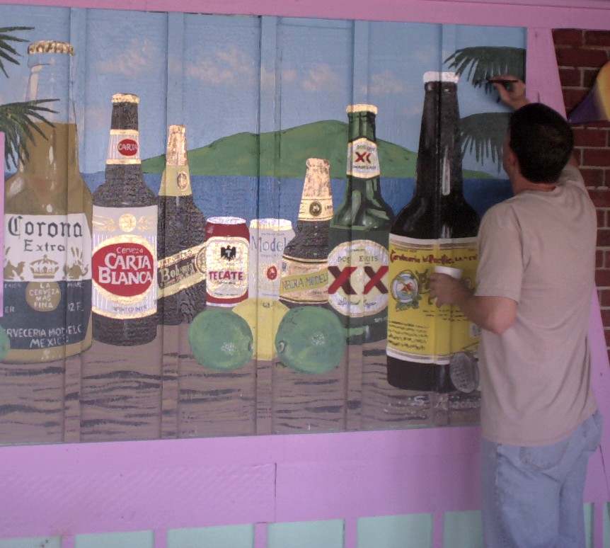 Shelton is putting the finishing strokes on a painted mural depicting the many cervezas of Mexico for Tacomania in Shreveport, LA.